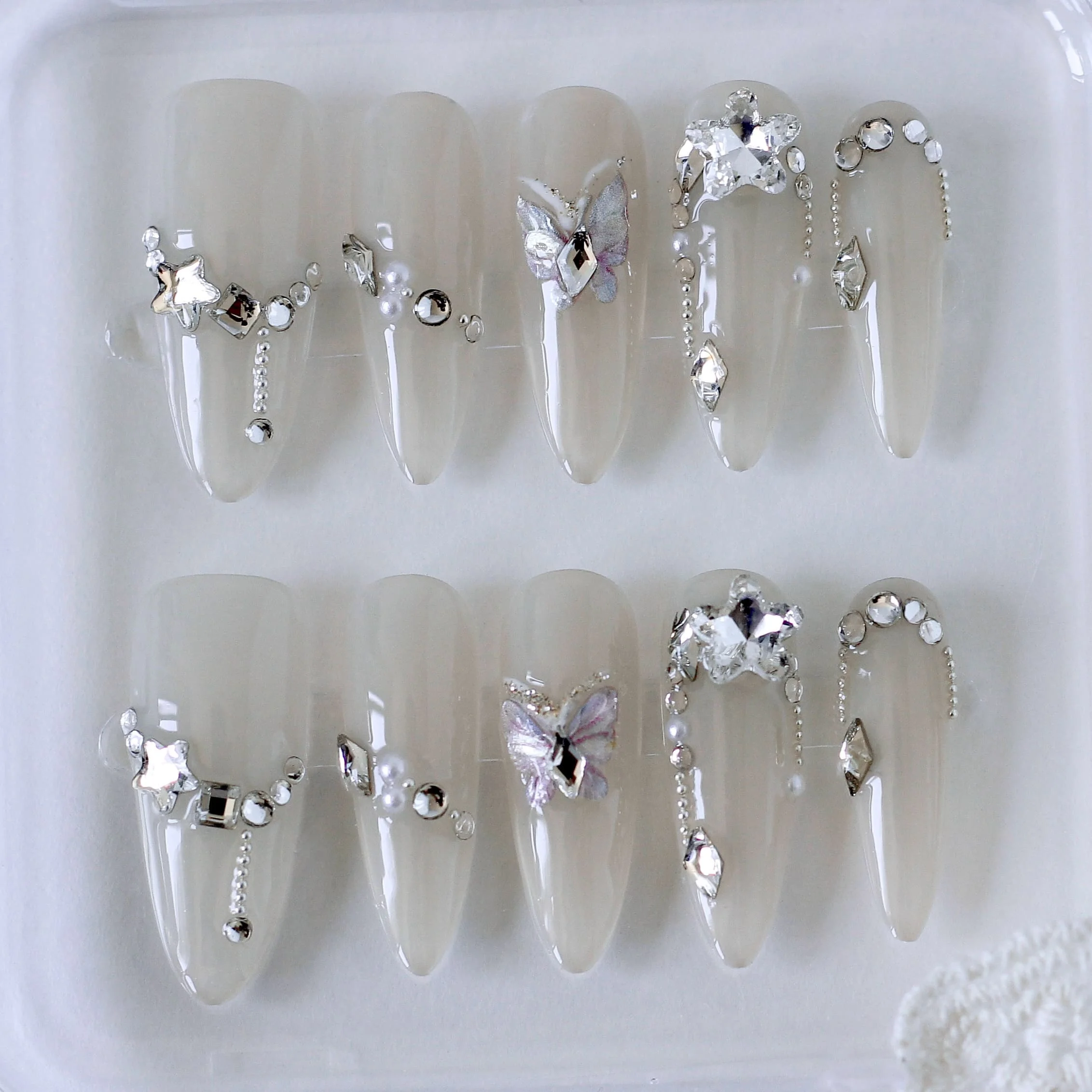 Uñas blancas con mariposas y diamantes-1 Uñas postizas press on blancas para festivales, bodas. Con mariposa y diamantes.
